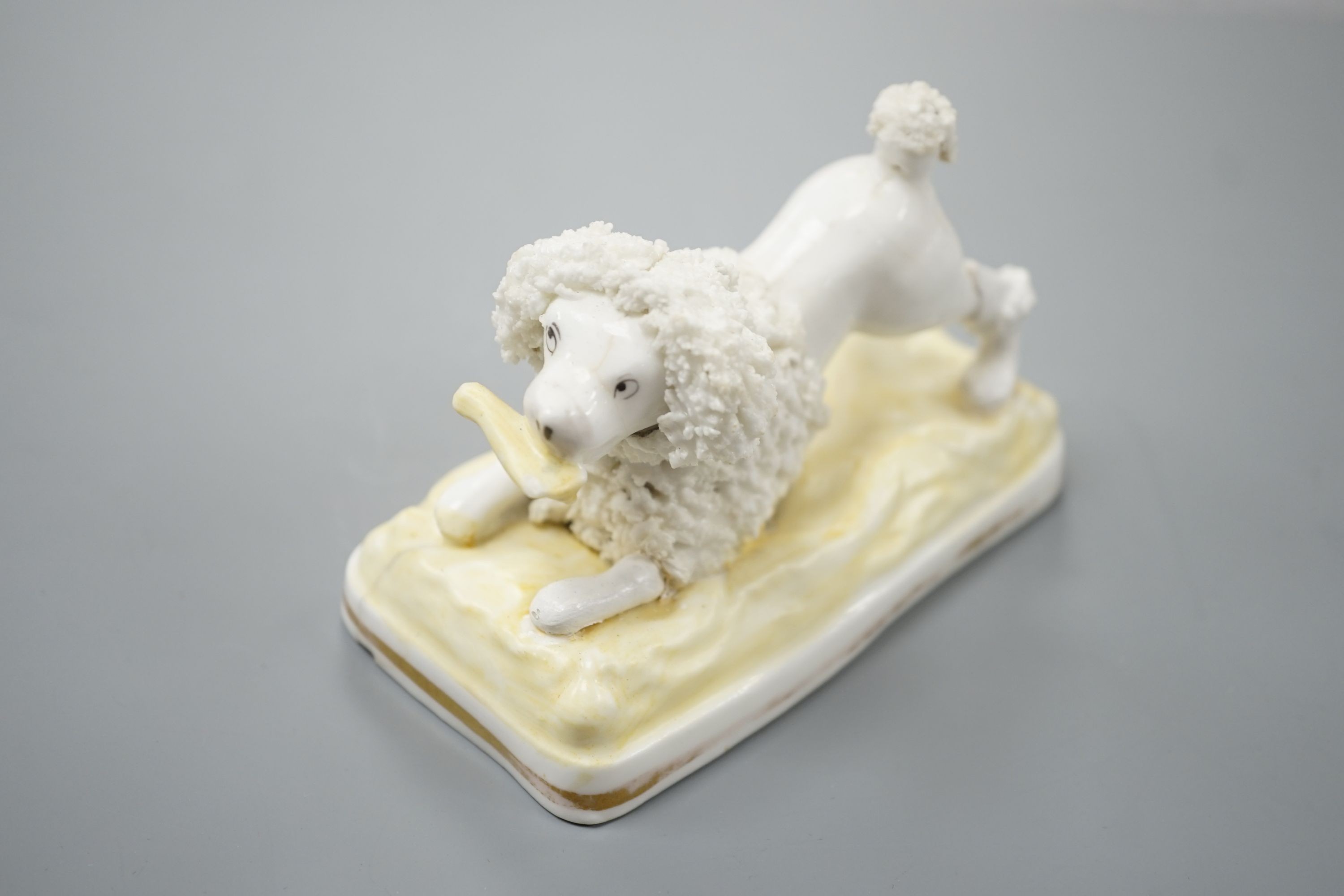 A Samuel Alcock model of a poodle grasping a bone, c.1835–50, 11.1 cm long, Cf. Dennis G.Rice Dogs in English porcelain, colour plate 64., Provenance: Dennis G.Rice collection